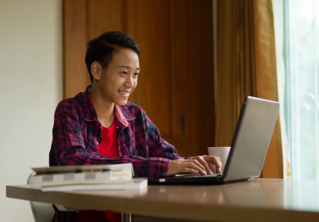 Student smiling while on laptop