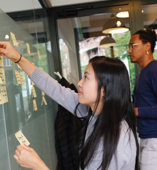 student putting notes on board