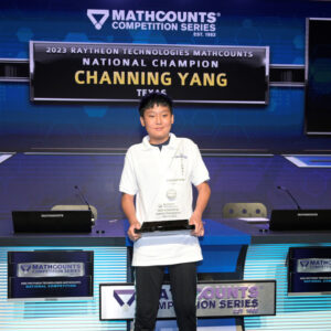 Channing Yang is presented with the 2023 Raytheon Technologies National Champion award by Bindu Nair, the director of basic research at the Office of the Under Secretary of Defense, his coach Andrea Smith, and Tracey Gray, MATHCOUNTS board chair and vice president of Communications and External Affairs for Raytheon Intelligence & Space.